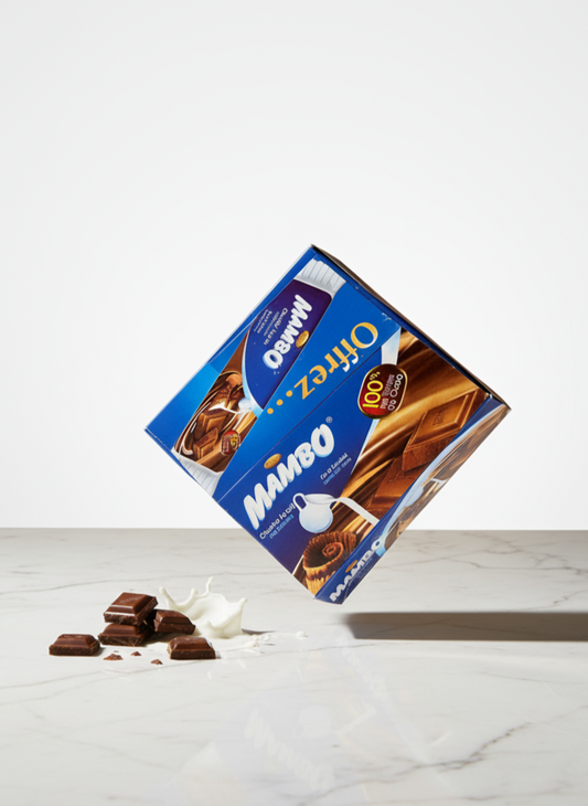 Mambo chocolate box on a white marble surface with a knife cutting through it.